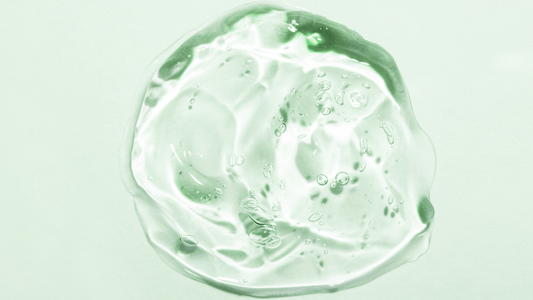 Close up of a hyaluronic acid gel texture on a green background representing natural hydrating skincare